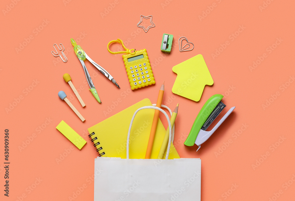 Composition with paper bag and various stationery on color background