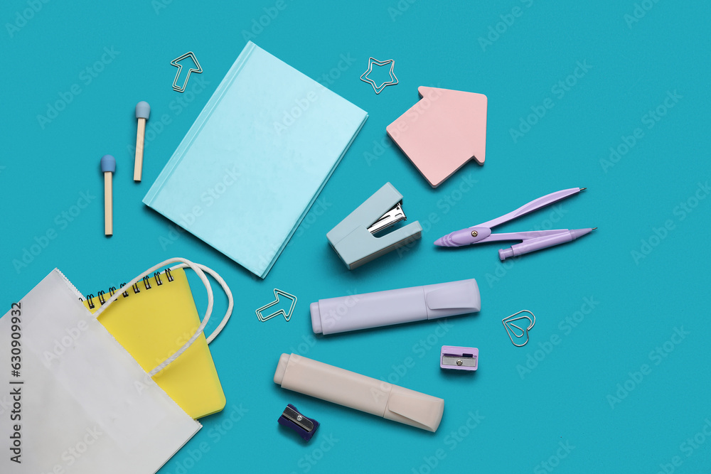 Shopping bag with different school stationery on turquoise background