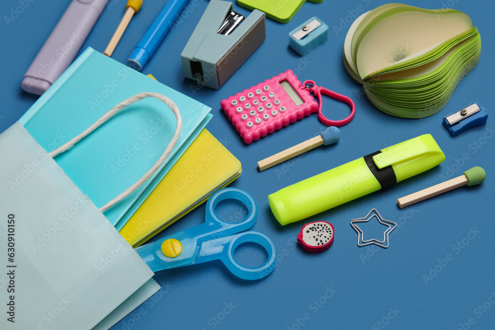 Pencil case with different school stationery on blue background, closeup