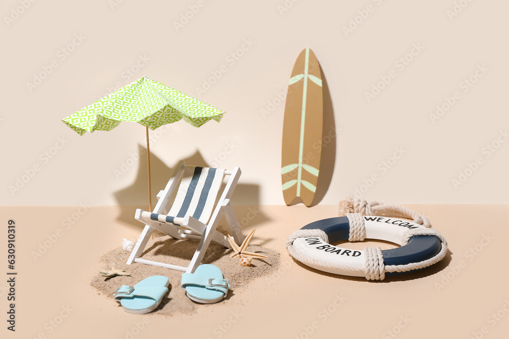 Creative summer composition with mini umbrella, deckchair and beach accessories on color background