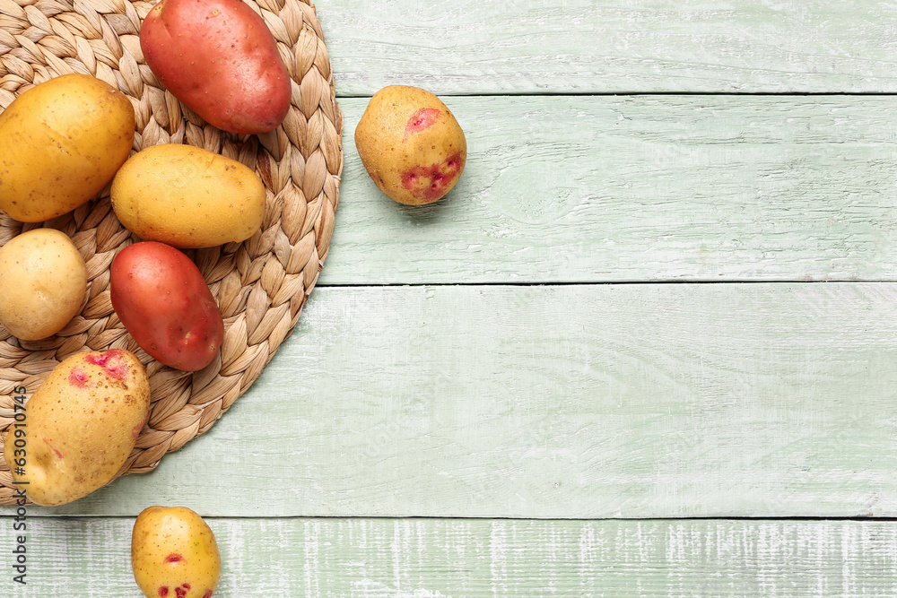 Fresh raw potatoes on green wooden background