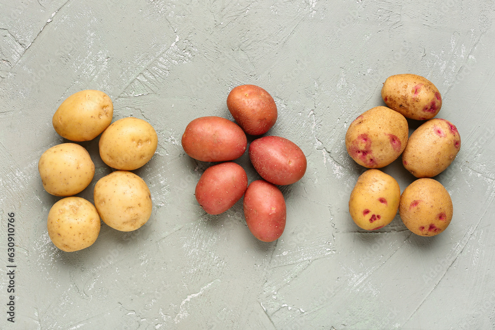 Fresh raw potatoes on grey background