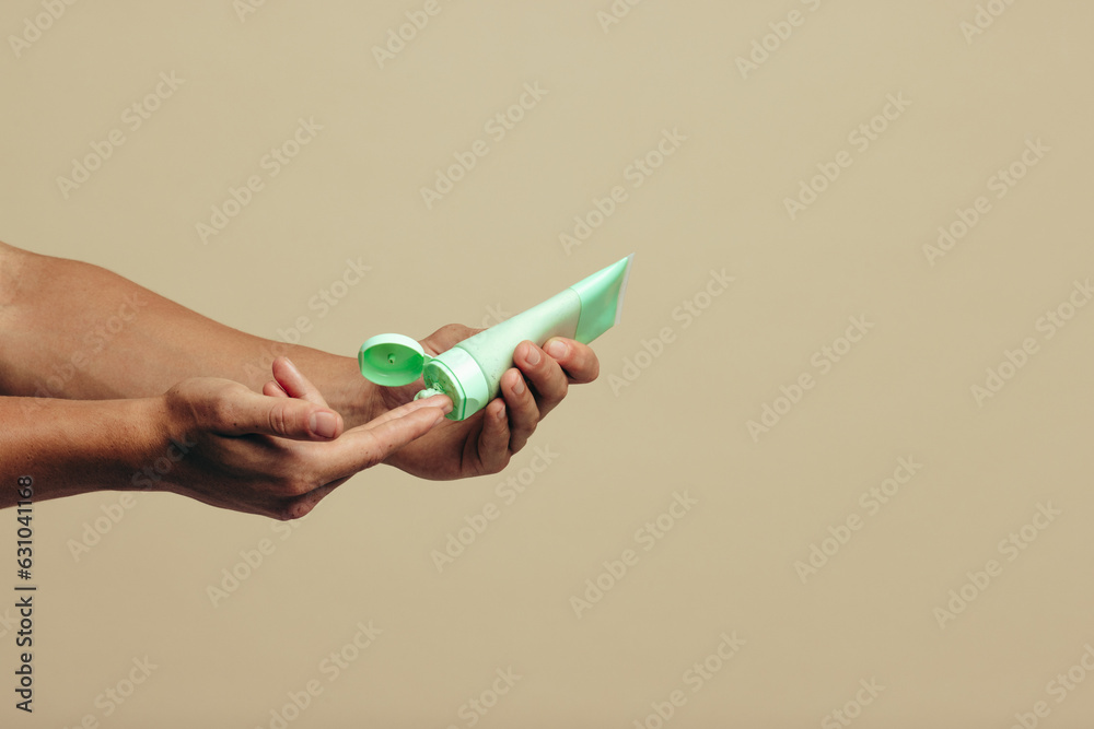 Male hands dispensing a facial mask cream for a skincare routine