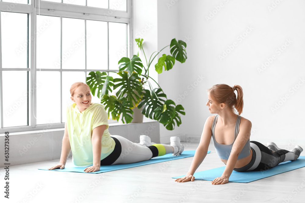 Young women practicing yoga  in gym