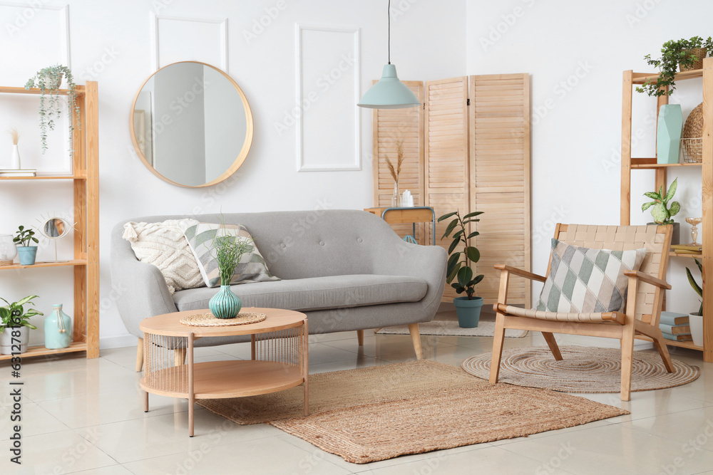 Interior of light living room with sofa, armchair and houseplants