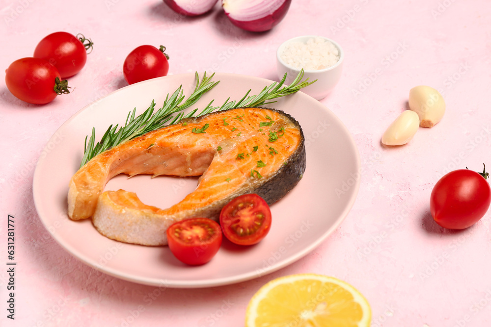 Plate of tasty salmon steak on pink background