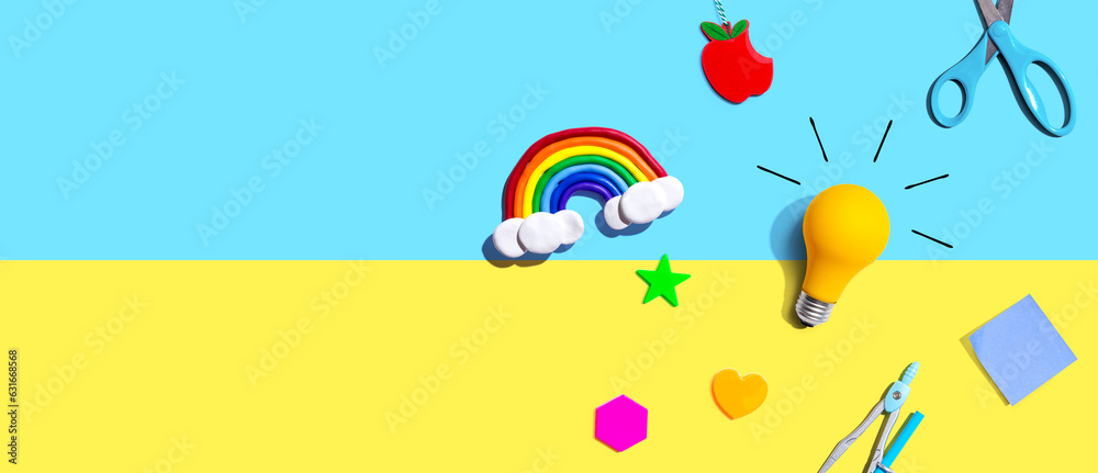 Idea light bulb with a rainbow and school supplies overhead view - flat lay