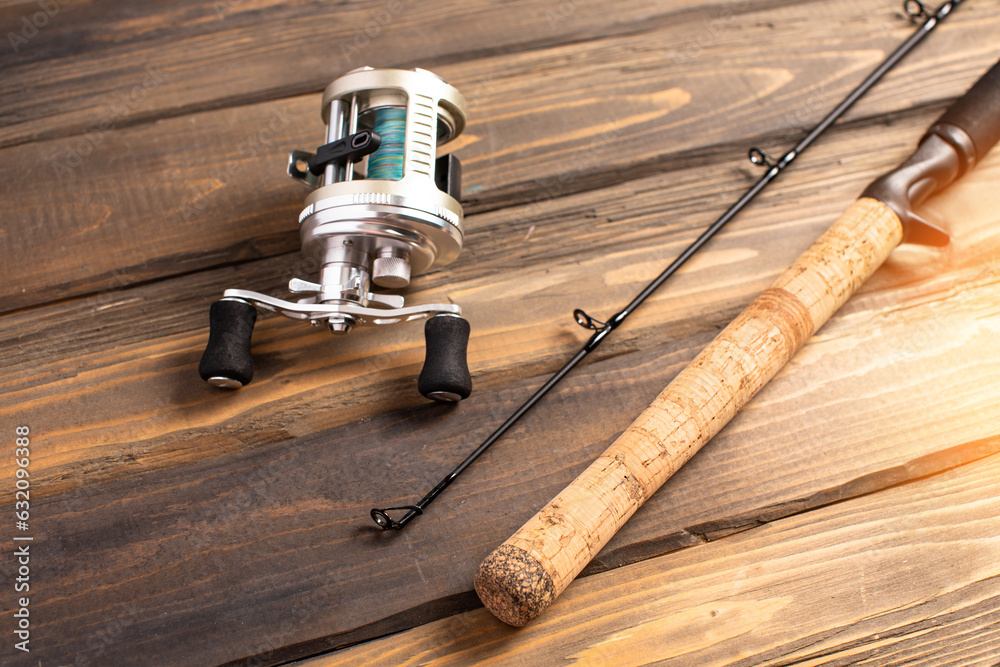 Spinning rod, spinning reel on wooden background