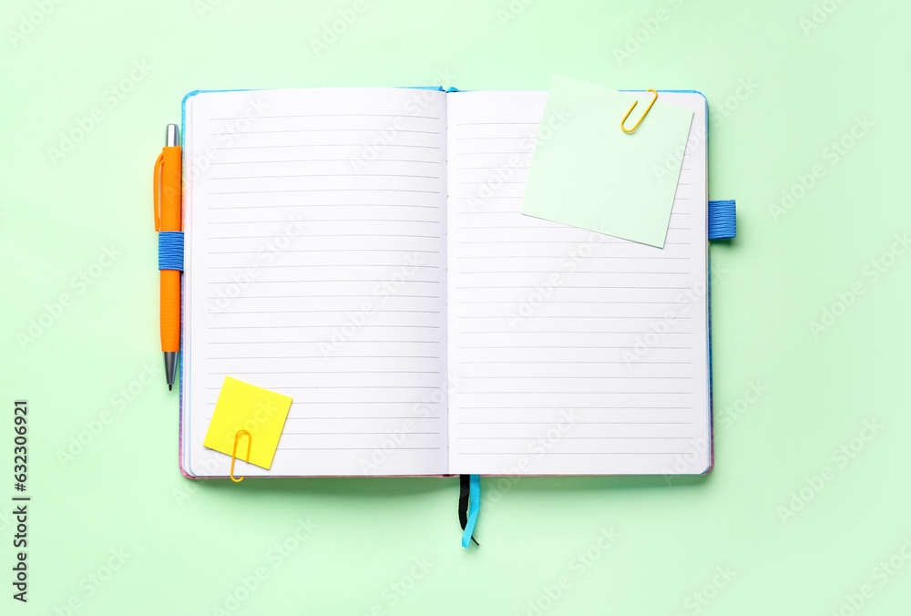 Sticky notes and notepad on green background