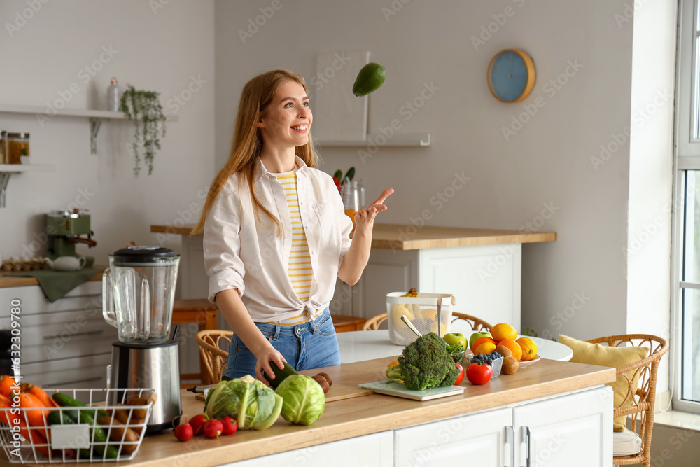 Young woman with avocado in kitchen