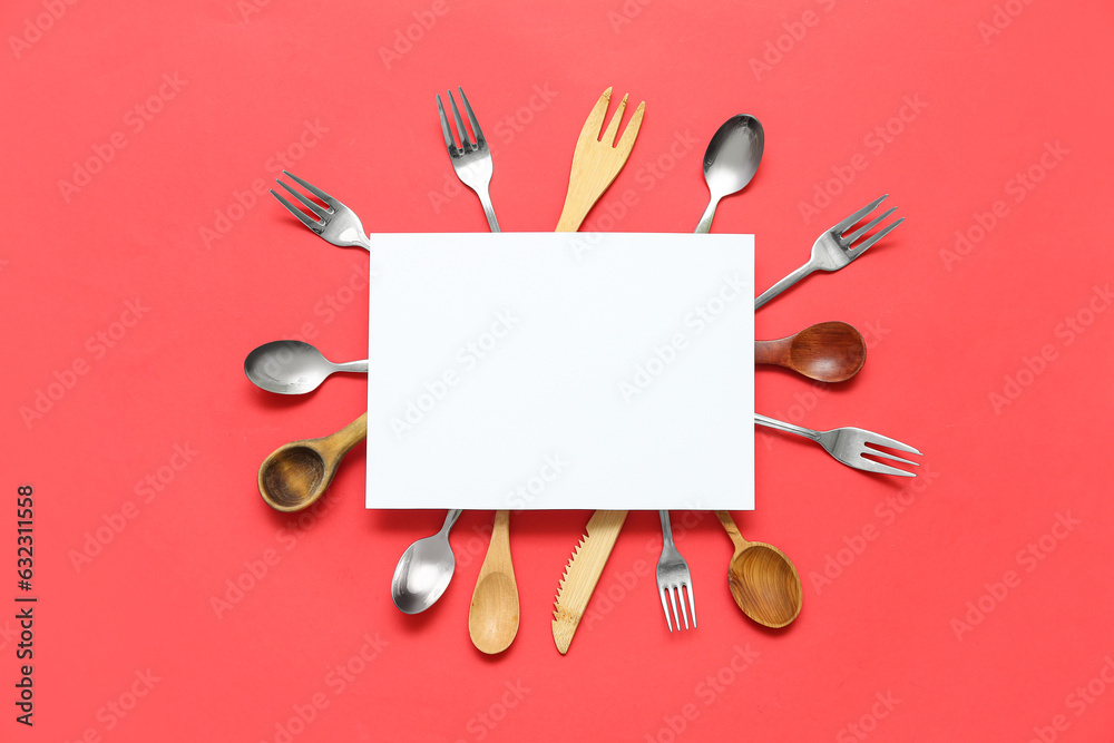 Frame made of blank card and kitchen utensils on red background