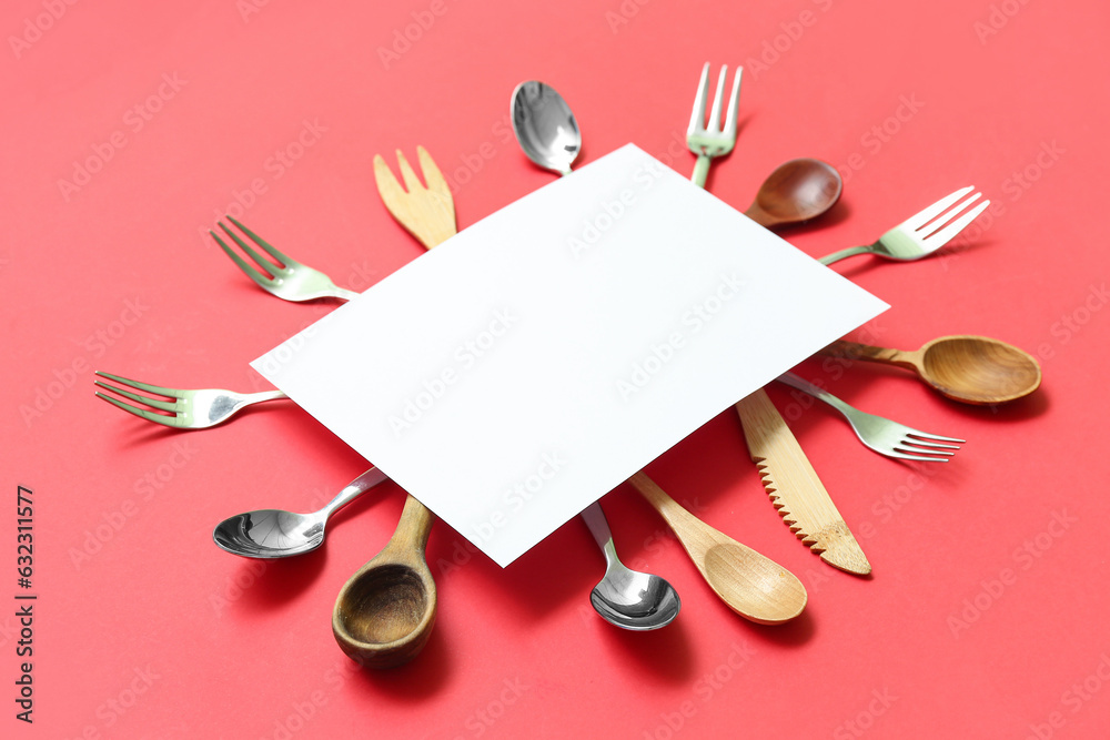 Frame made of blank card and kitchen utensils on red background