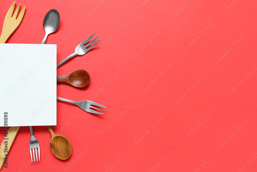 Frame made of blank card and kitchen utensils on red background