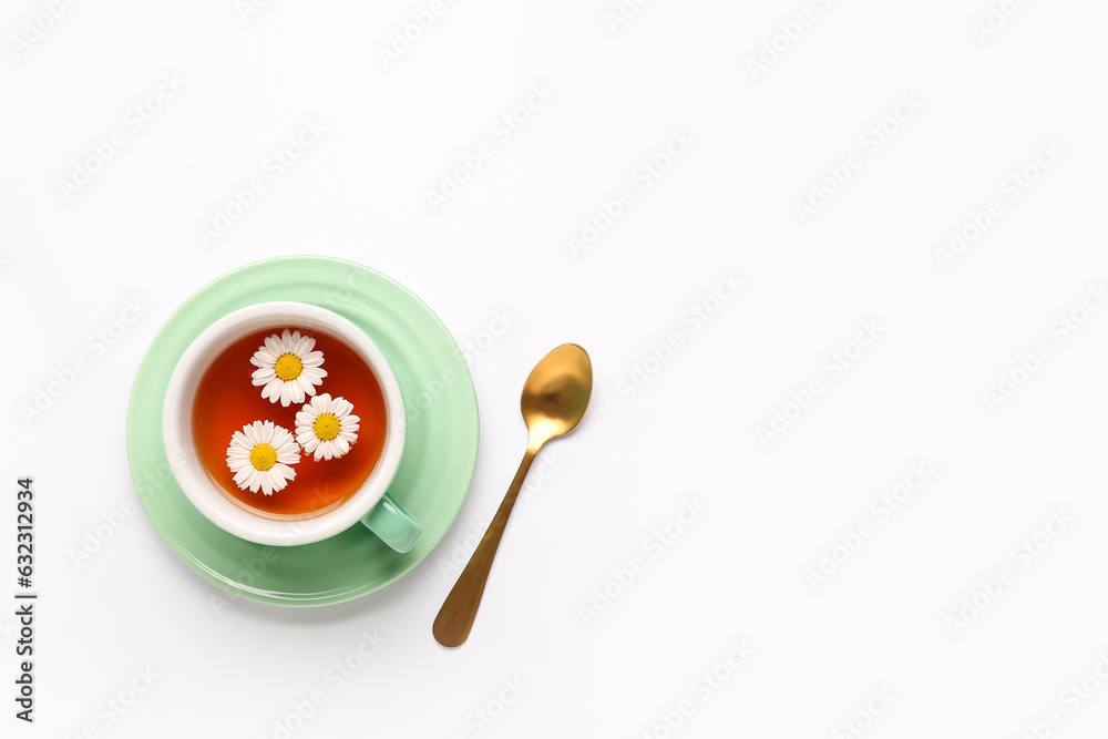 Cup of natural chamomile tea and flowers on white background