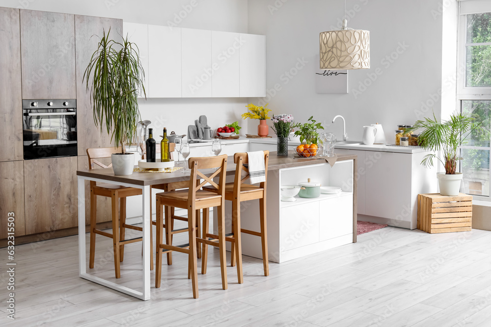 Interior of light kitchen with stylish island table