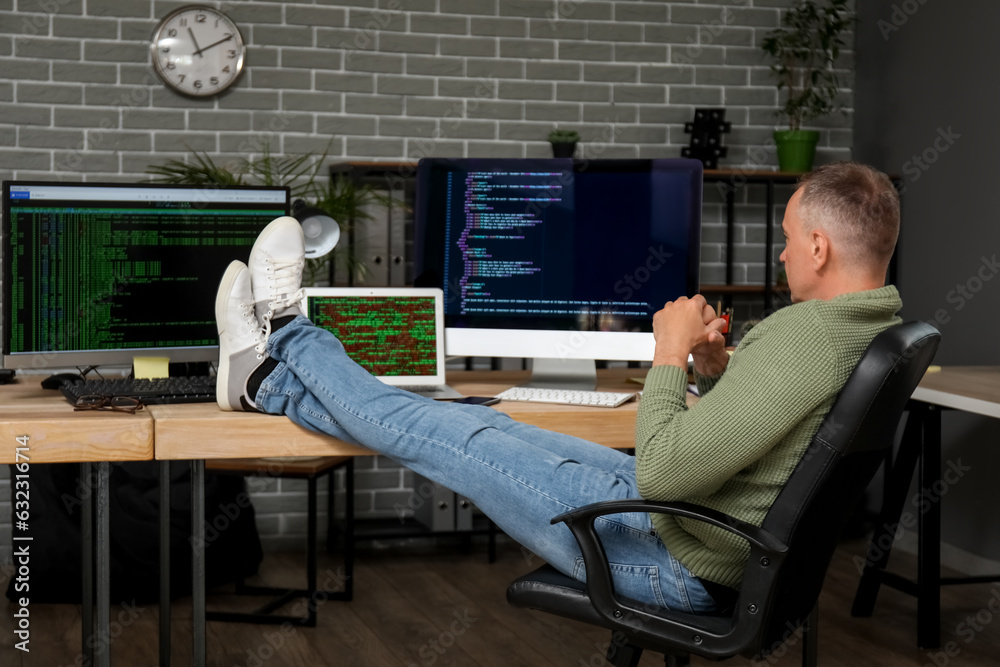 Mature male programmer sitting in office at his workplace