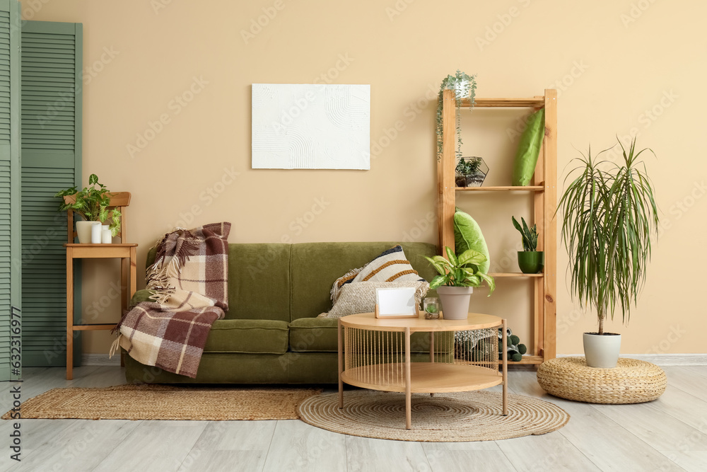 Interior of living room with cozy green sofa, wooden coffee table and shelving unit