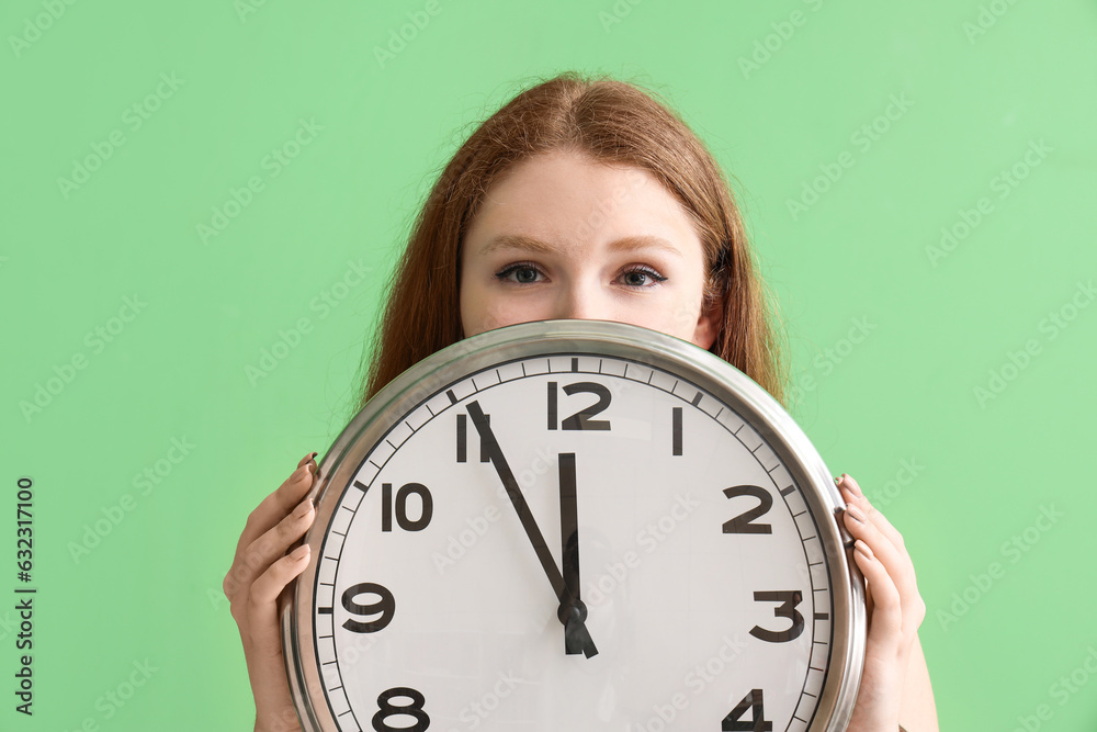 Young woman with clock on green background, closeup. Deadline concept