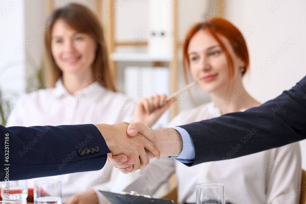 Human resources manager shaking hands with male applicant in office