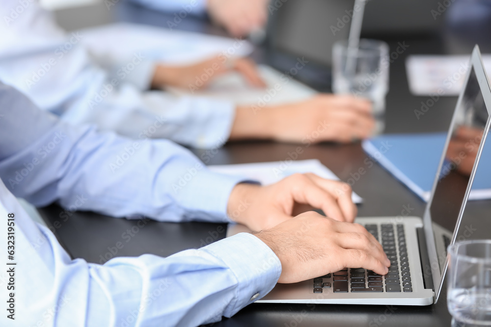 Male business consultant working with laptop at table in office, closeup