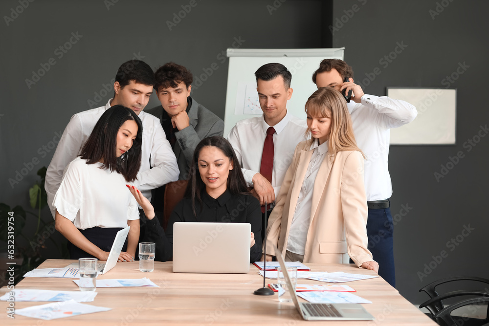 Group of business consultants working with laptop at table in office