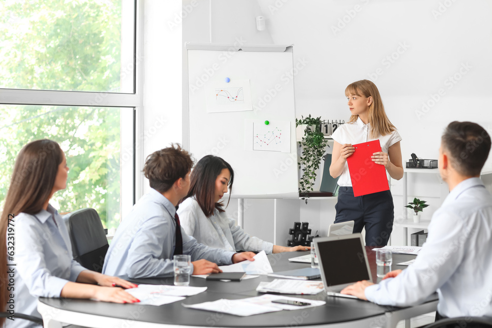 Female business consultant giving presentation to her colleagues in office