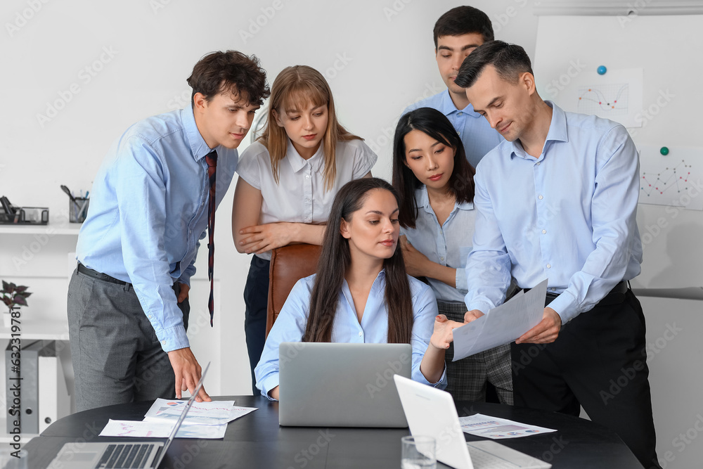 Group of business consultants working with laptop at table in office