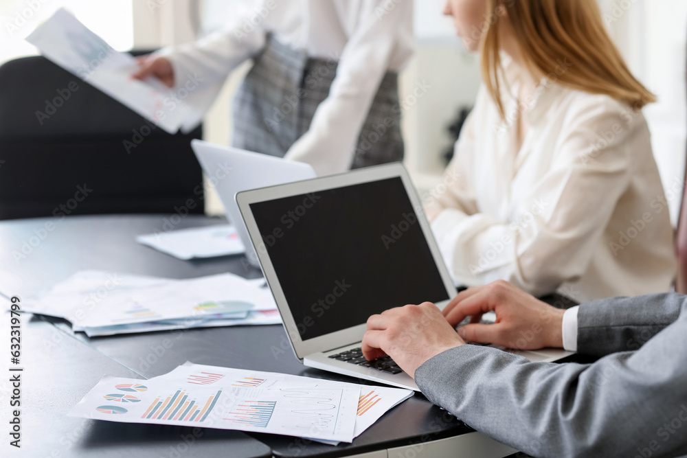 Male business consultant working with laptop at table in office, closeup