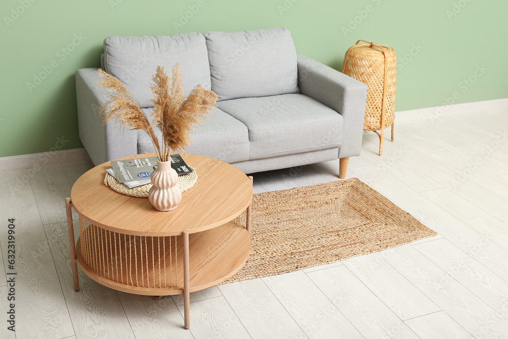 Modern living room interior with comfortable grey sofa and wooden coffee table