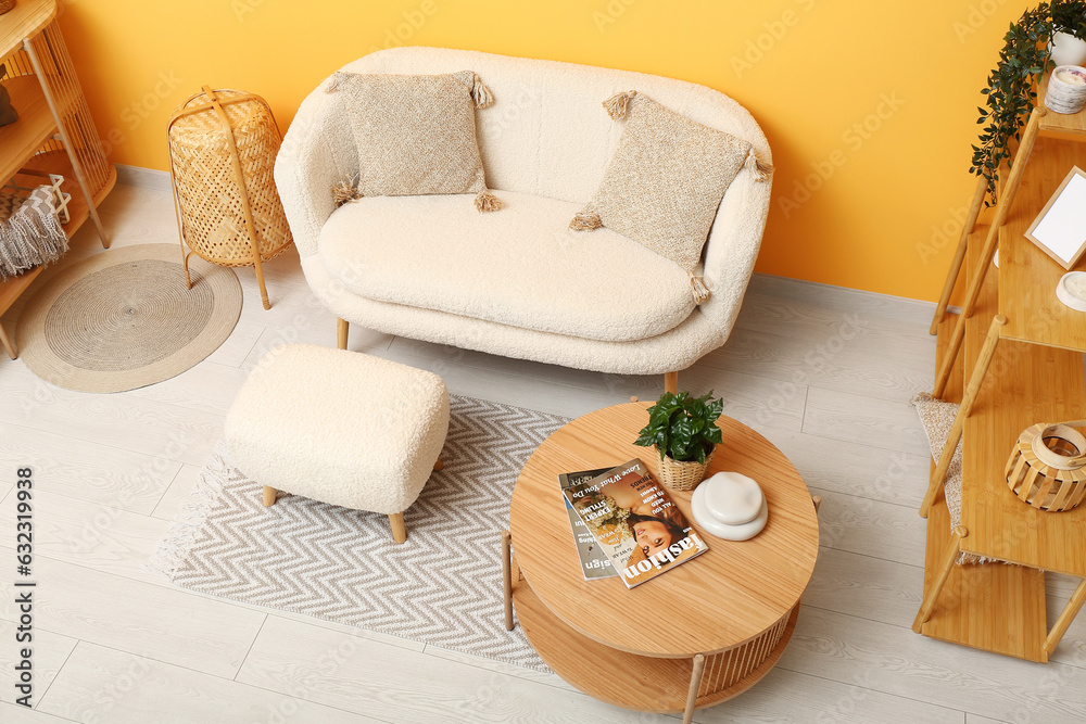 Modern living room interior with comfortable white sofa, ottoman and wooden coffee table