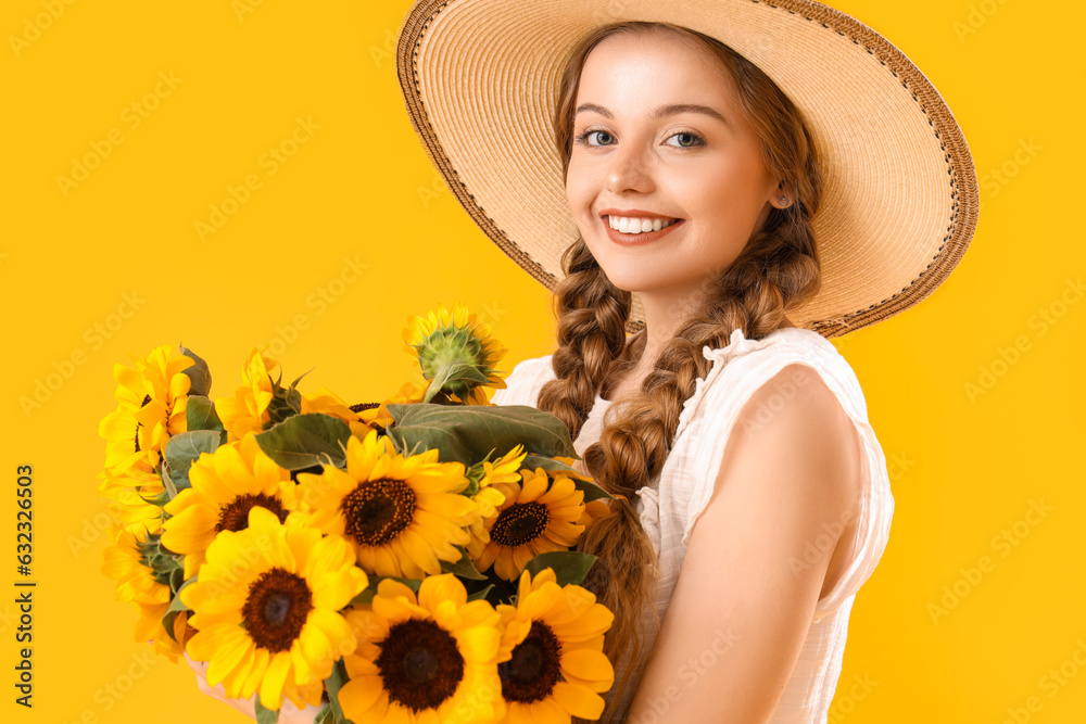 Young woman with beautiful sunflowers on yellow background