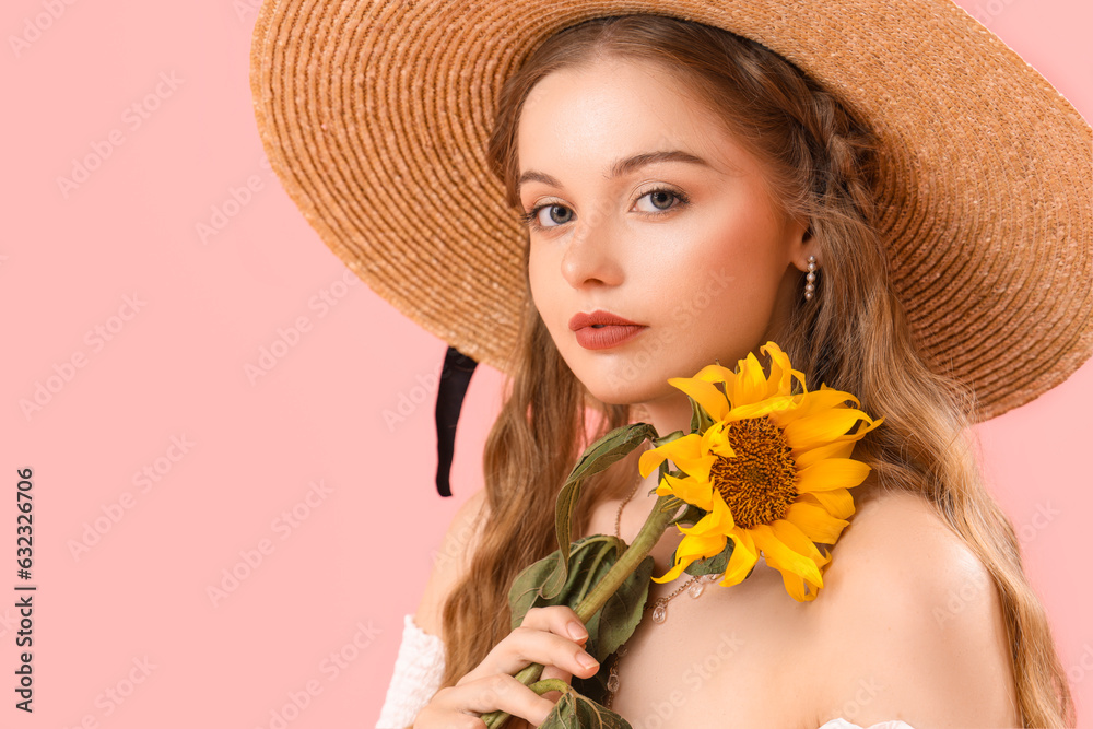 Young woman with beautiful sunflower on pink background, closeup