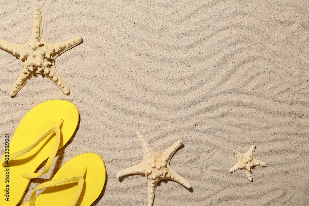 Flip-flops with starfishes on sandy beach