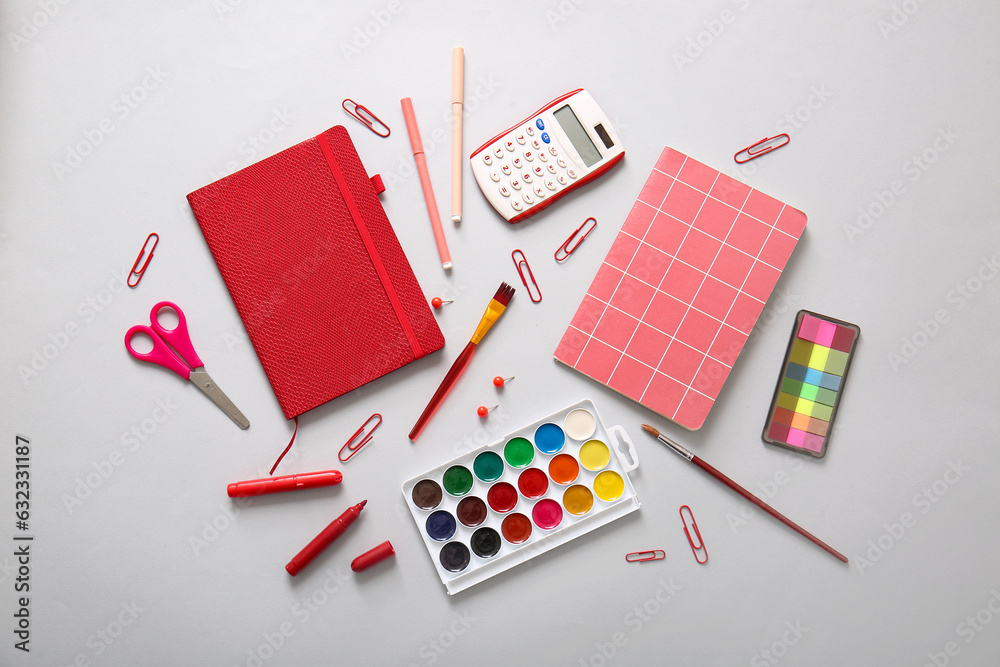 Different school stationery and notebooks on grey background