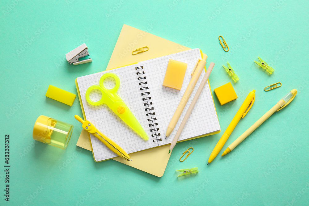 Different school stationery and notebooks on turquoise background