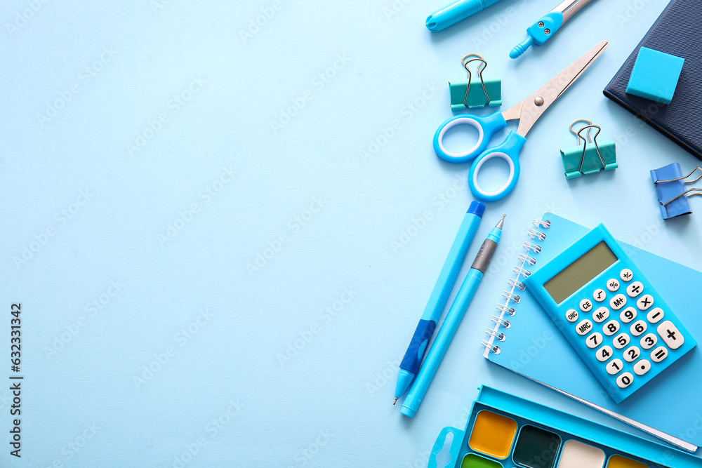 Different school stationery and notebooks on blue background