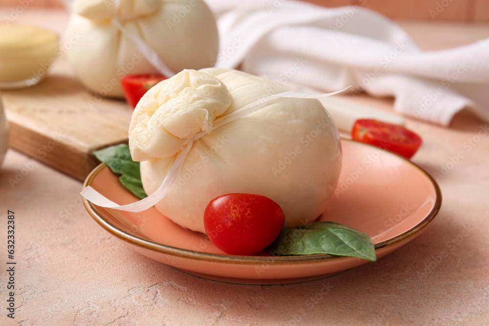 Plate with tasty Burrata cheese on beige background