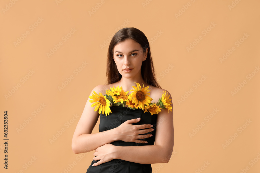 Young woman with bouquet of beautiful sunflowers on orange background