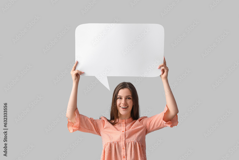 Beautiful happy young woman with speech bubble on grey background