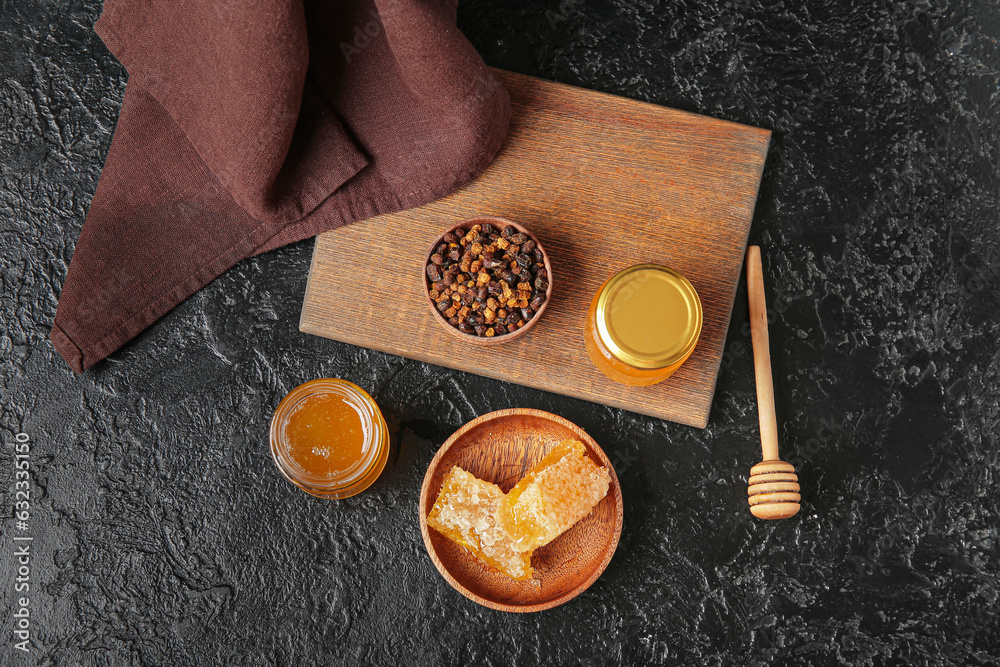 Composition with tasty honey, combs and beebread on dark background