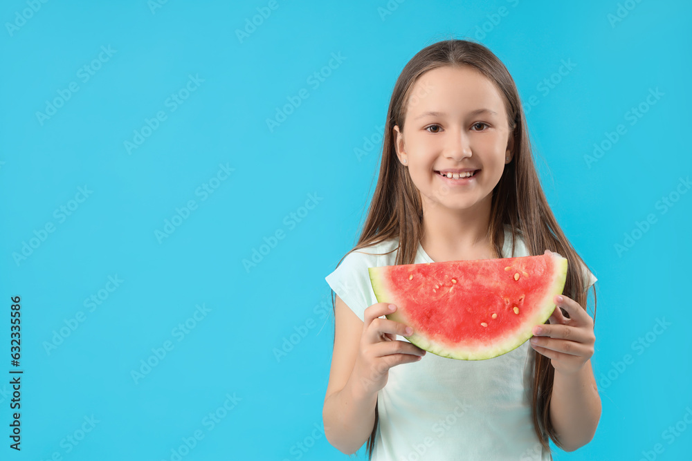 Happy little girl with slice of fresh watermelon on blue background