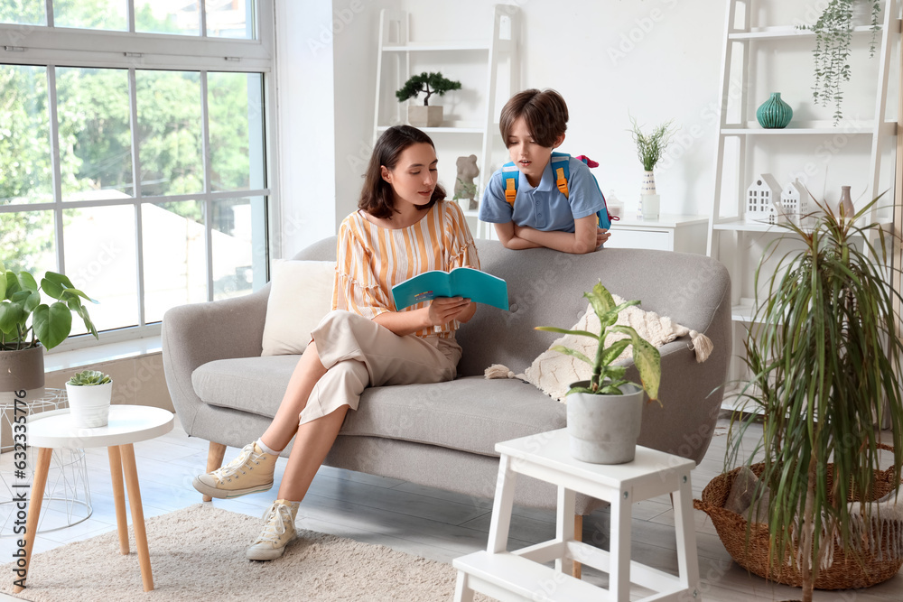 Mother helping her little son with homework at home