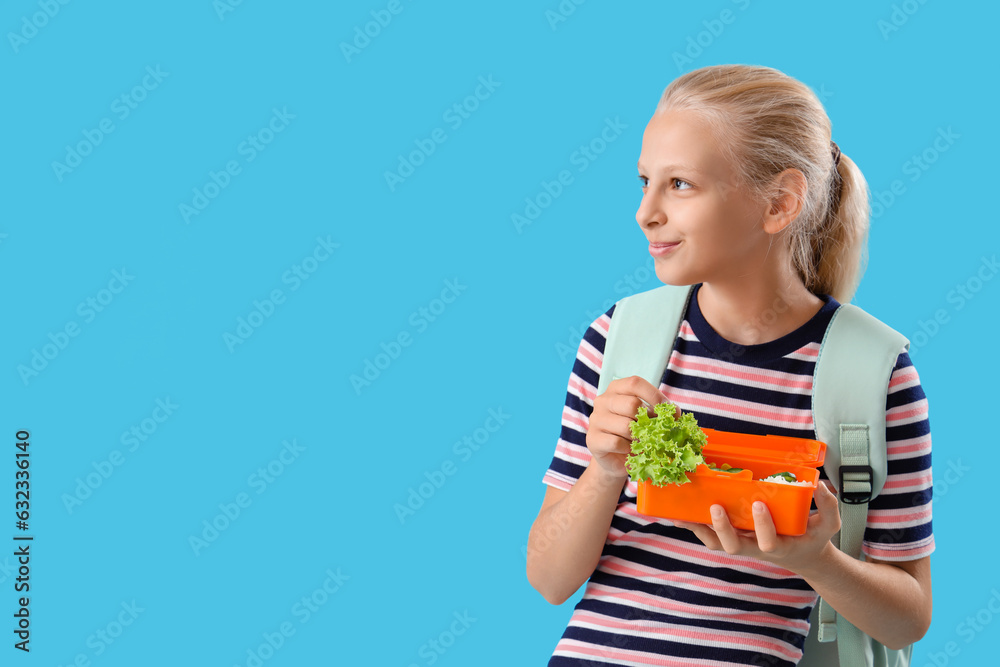 Happy girl with backpack and lunchbox on blue background