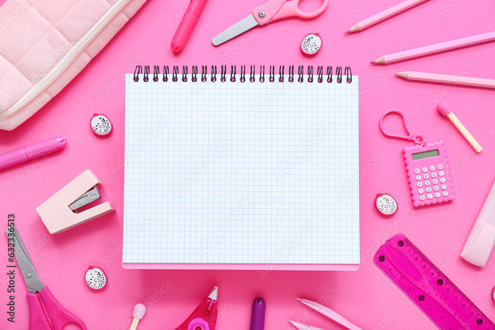 Notebook and pencil case with different stationery supplies on pink background