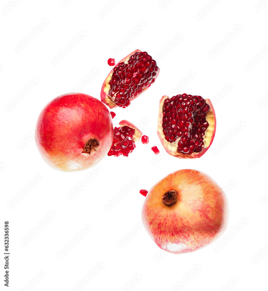 Flying fresh pomegranates with seeds on white background