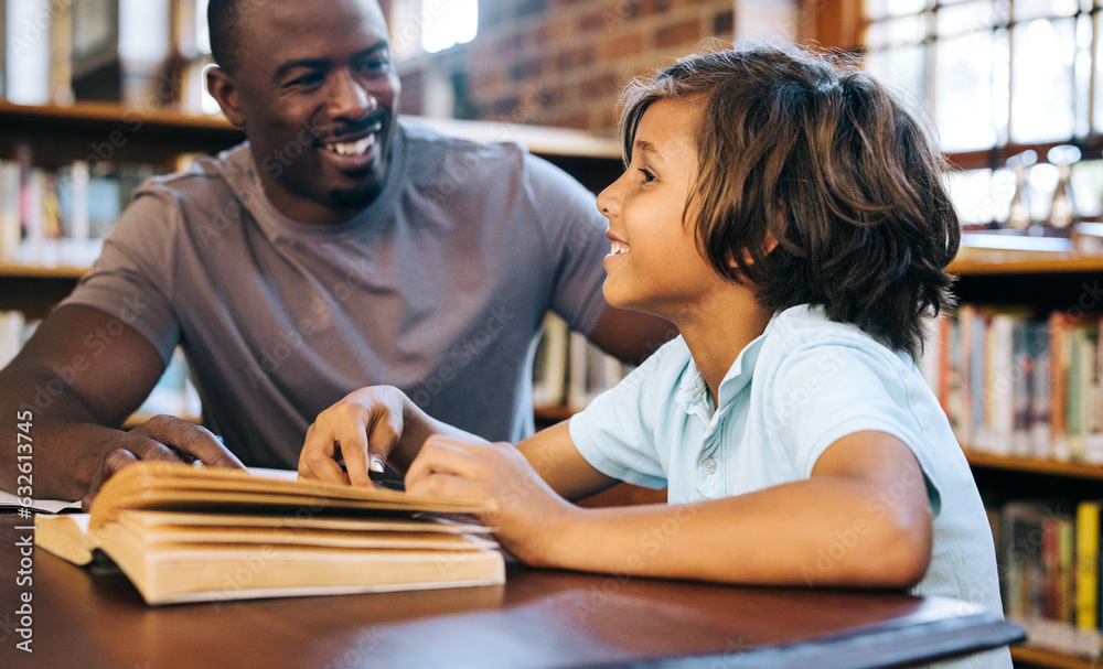 School teacher tutoring a young boy in a library