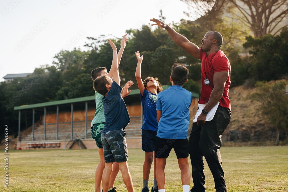 School children celebrating with their coach during PE