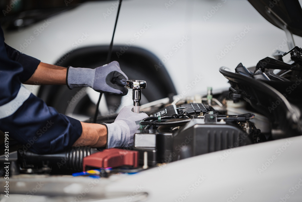 Professional mechanic working on the engine of the car in the garage. Car repair service.