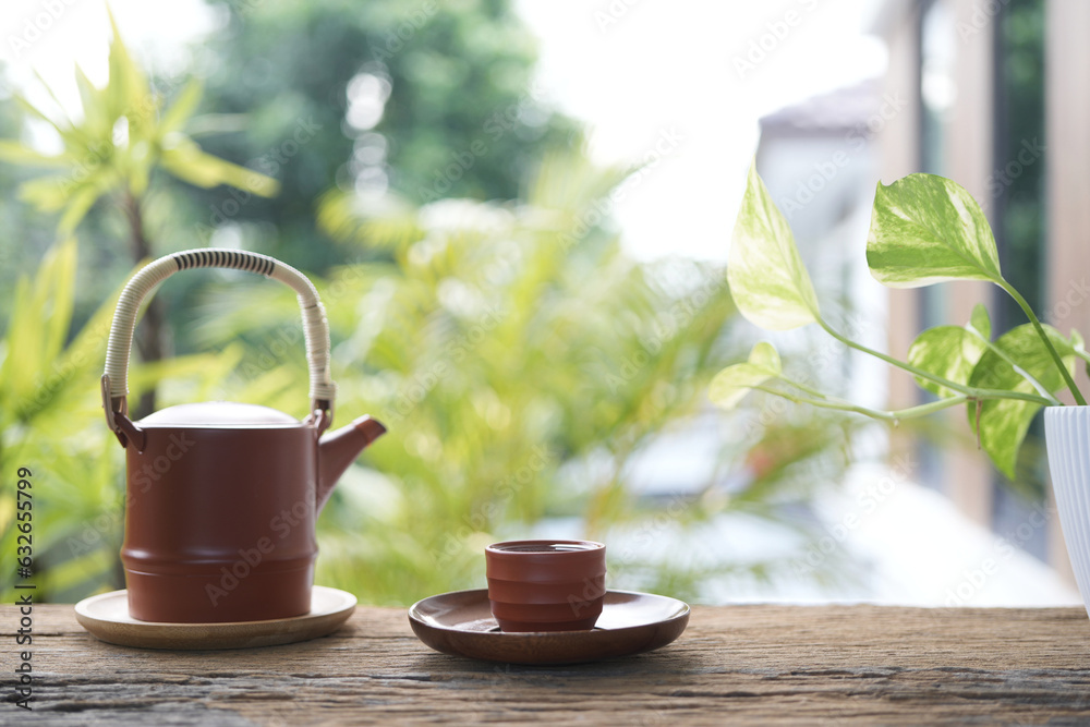 Earthenware teapot and tea cup on wooden table