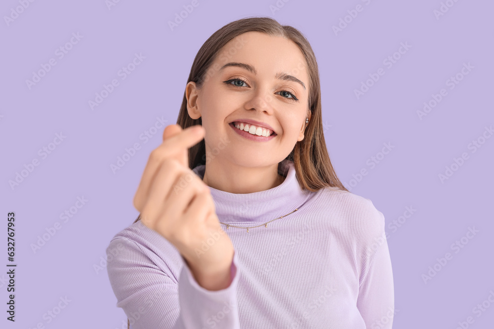 Young woman in sweater snapping fingers on lilac background, closeup